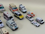 many different types of toy ambulances on a white surface
