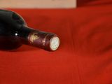 a bottle of wine sitting on a red cloth
