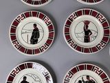 six plates with black and red designs on them sitting on a table