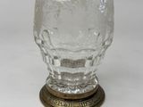 an old fashioned glass cup with a gold base on a white background