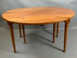 une table à manger ovale à deux pieds, avec un plateau en bois