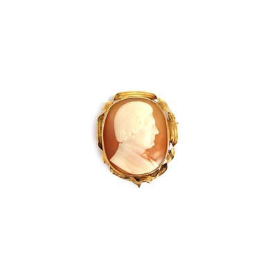 un gros plan d'une bague en or sur laquelle figure le portrait d'un homme