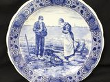 une assiette bleue et blanche sur laquelle sont représentés un homme et une femme