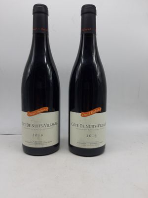 deux bouteilles de vin rouge posées sur une table blanche