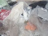 a pile of clothes in plastic bags on the floor