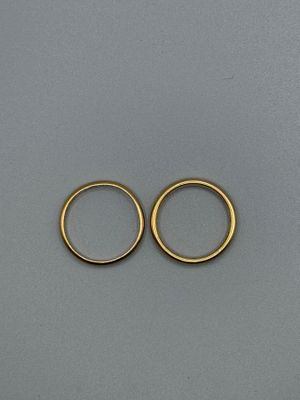 a pair of gold hoop earrings on a gray surface