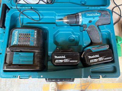 une boîte à outils bleue avec des outils sur le sol