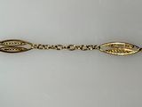 a close up of a gold bracelet on a white surface