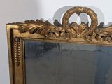 a mirror with a gold frame on a white wall