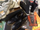 several pairs of black and white shoes and a book on a table