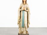 a statue of the virgin of guadalupe in a white room