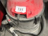 un aspirateur rouge posé par terre à côté d'un outil