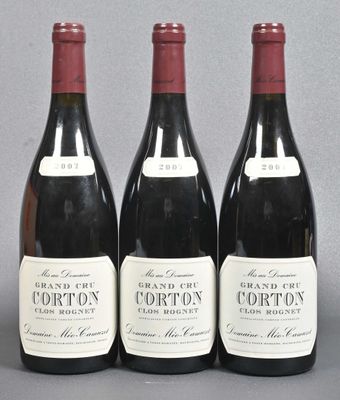 three bottles of red wine are lined up on a table