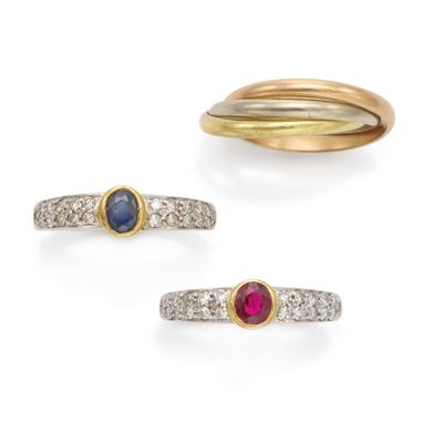 trois pierres de couleurs différentes et des bagues en or sur fond blanc