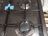 a black stove top with four burners on it