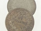 two silver coins with a wreath on top of them on a white surface