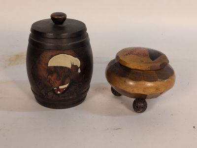un petit récipient en bois muni d'un couvercle, à côté d'un récipient en bois plus petit