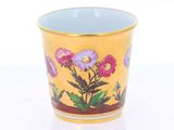 une tasse sur laquelle sont peintes des fleurs sur un fond blanc