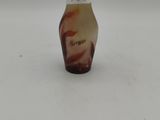 a small glass vase with a brown and white design on it