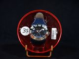 a blue watch sitting on a red plate on a black background