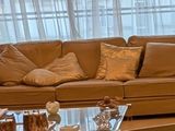 un salon avec un canapé, un fauteuil, une table basse et une lampe