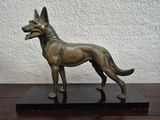 statue of a german shepherd dog on a black base on a table