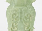un vase vert surmonté d'un oiseau