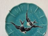 deux oiseaux posés sur une assiette posée sur une table