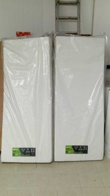 three white mattresses stacked on top of each other in a room