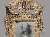 un cadre ancien dans lequel est encadrée une image représentant une femme et deux anges
