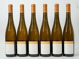 six bottles of wine are lined up on a white surface