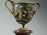 a vase that has a statue on top of it