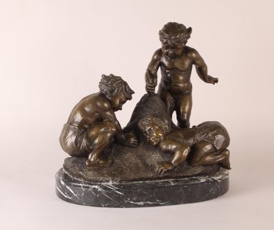 statue en bronze représentant un garçon et deux autres garçons jouant avec un chien
