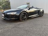 a black audi sports car parked in front of a building