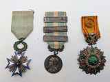 trois médailles et une médaille sur une surface blanche