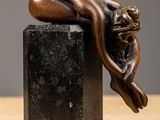 bronze sculpture of a sleeping woman on a black marble block