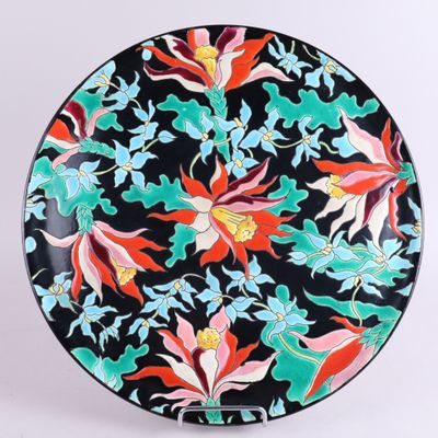 un gros plan sur une assiette noire ornée de fleurs colorées