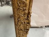 an image of a gold mirror with ornate designs on it