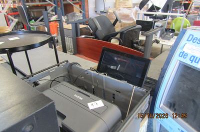 un ordinateur portable posé sur une imprimante dans une pièce