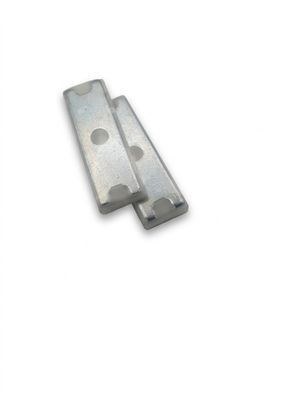 two pieces of metal on a white surface