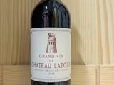 a bottle of red wine sitting on a wooden shelf