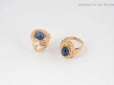 two gold rings with a blue stone in the middle