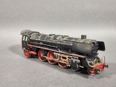 une locomotive noire et rouge sur un fond gris