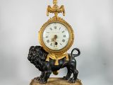 a gold clock with a lion on top of it
