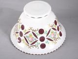 a white bowl with red and yellow designs on it