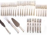 a lot of forks, knives and spoons laid out on the table