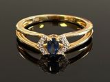 an image of a blue sapphire and diamond ring on a black surface