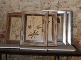 three framed pictures on a table in front of a brick wall