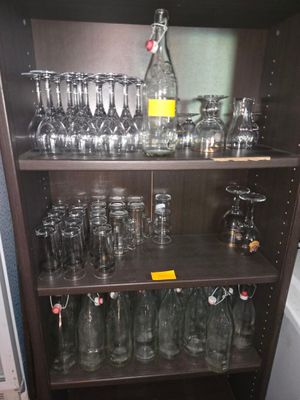 des bouteilles et des verres posés sur une étagère dans une pièce équipée d'une baignoire