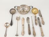 beaucoup de cuillères en argent et d'autres objets en argent sur une table